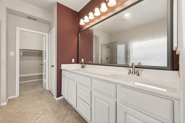 a bathroom with a double vanity sink and a mirror