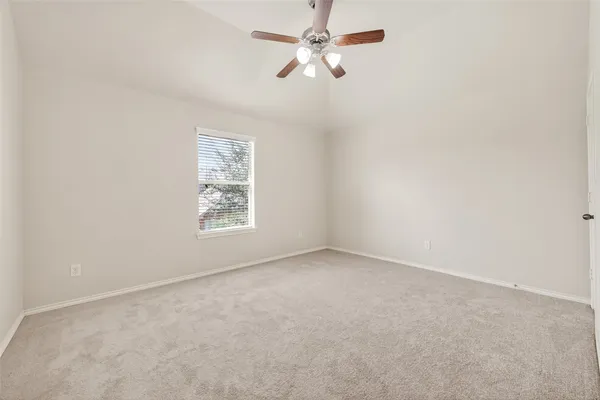 an empty room with a window and a fan