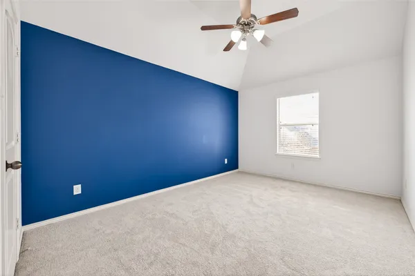 an empty room with a fan & a window