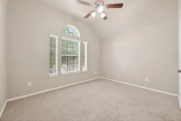 an empty room with a window and a fan