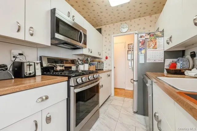 a kitchen with stainless steel appliances granite countertop a refrigerator and a stove top oven