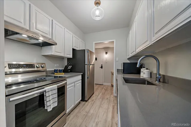 a kitchen with stainless steel appliances granite countertop a stove a sink and a refrigerator
