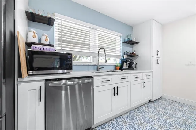 a kitchen with stainless steel appliances granite countertop a stove a sink and a microwave