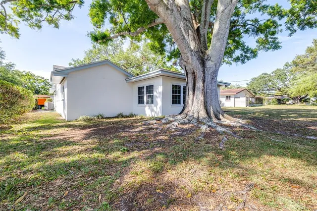 a view of a house with yard and tree s
