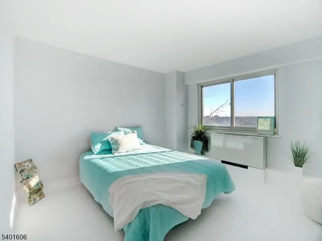 a bedroom with a bed table and a window