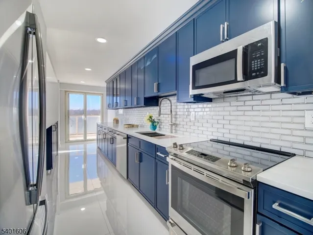 a kitchen with stainless steel appliances a stove microwave and sink