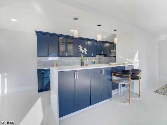 a kitchen with a sink a stove a refrigerator cabinets and a dining table