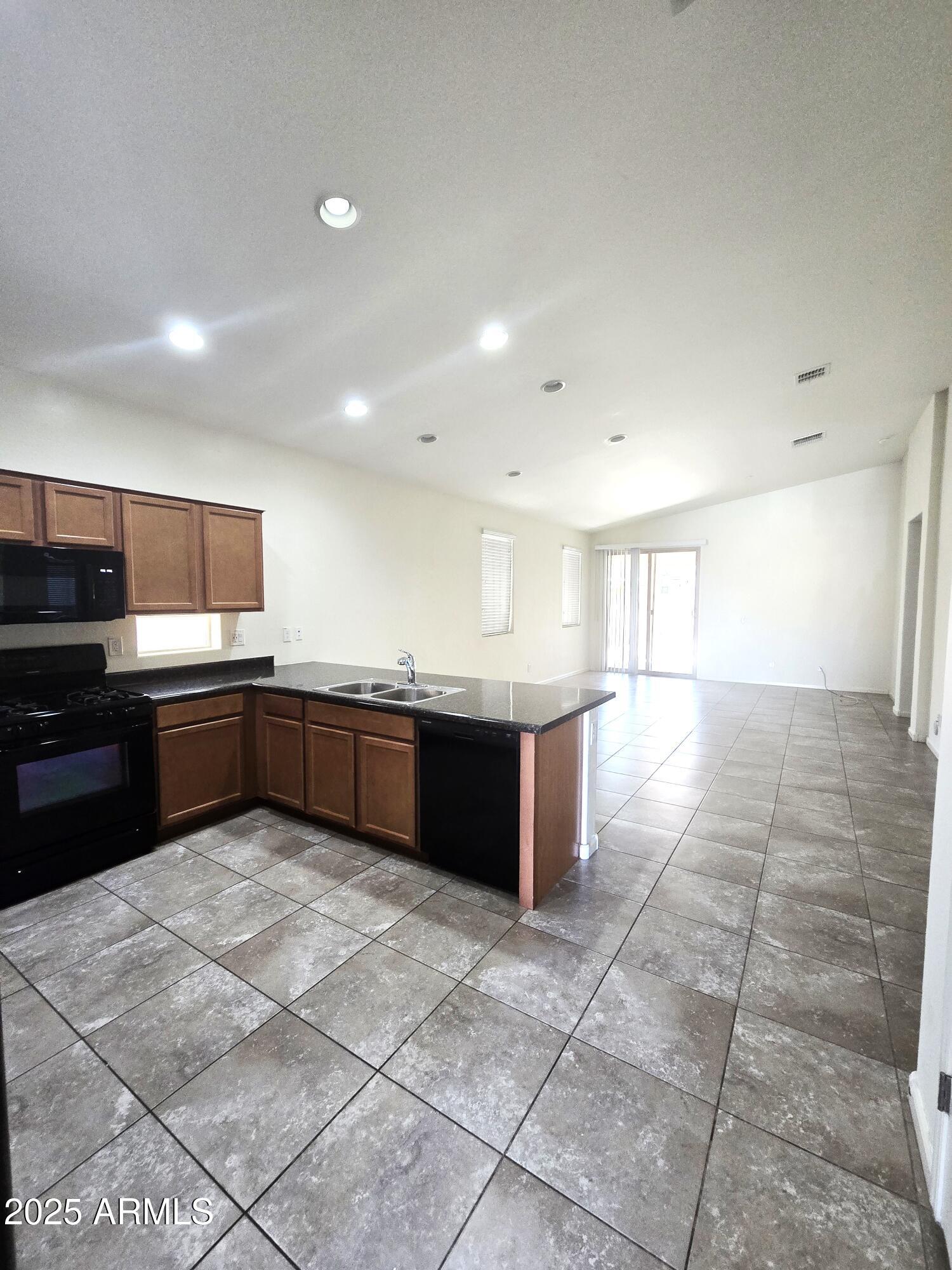 3931 East Narrowleaf Drive Gilbert, AZ 85298 - Photo 3 of 7 a large kitchen with a large counter top stainless steel appliances and cabinets