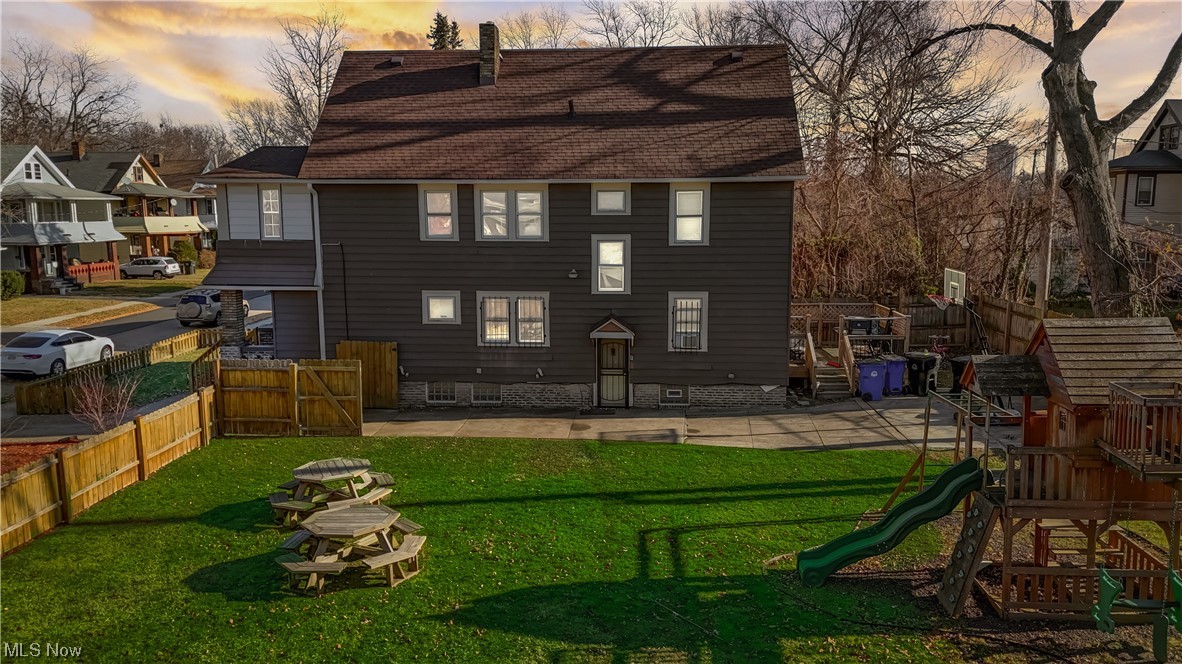 14202 Glenside Road Cleveland, OH 44110 - Photo 3 of 41 Side of house at dusk featuring a yard and a playground