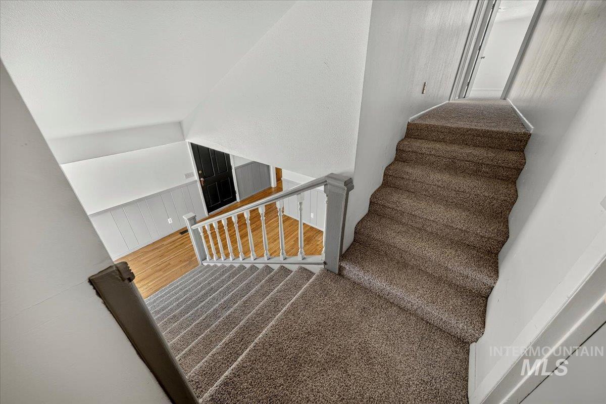 2160 South Five Mile Road Boise, ID 83709 - Photo 24 of 41 Carpeted staircase with white balusters and a dark handrail