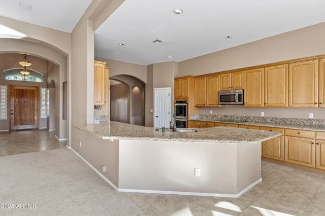 a kitchen with stainless steel appliances granite countertop a stove top oven a sink a counter space and cabinets