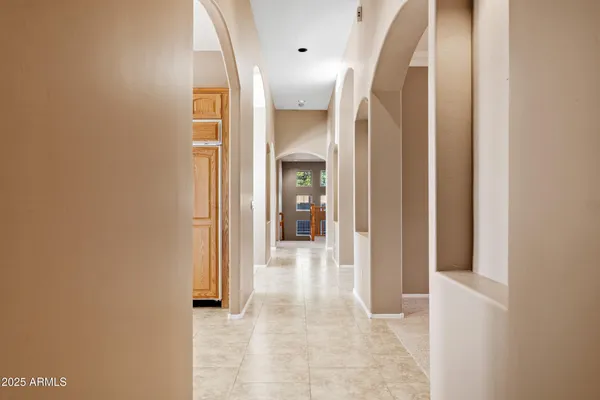 a view of an empty room with window and chandelier fan