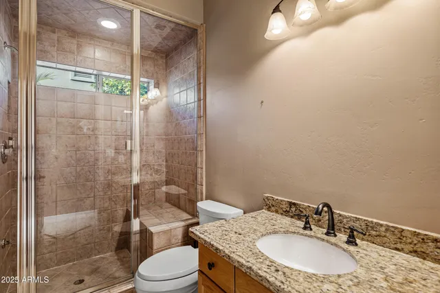 a bathroom with a granite countertop double vanity sink and a mirror