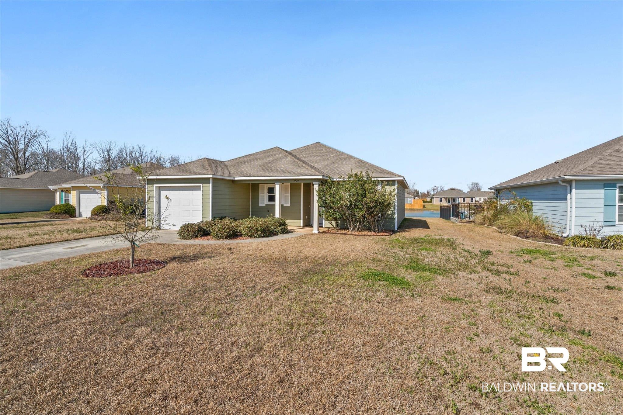919 Sailor Circle Foley, AL 36535 - Photo 22 of 24 Ranch-style house featuring covered porch, concrete driveway, a front lawn, roof with shingles, and a garage
