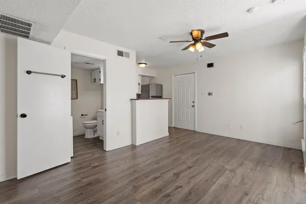 a view of a kitchen with wooden floor and a ceiling fan