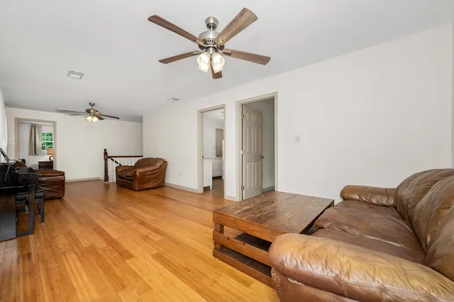 a living room with furniture ceiling fan and a rug