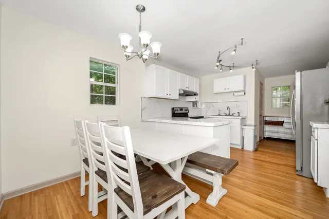 a kitchen with stainless steel appliances a dining table chairs and granite counter tops