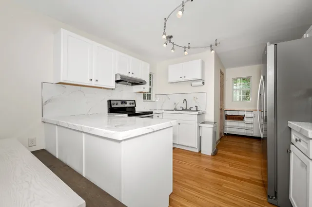 a kitchen with a sink a stove and cabinets