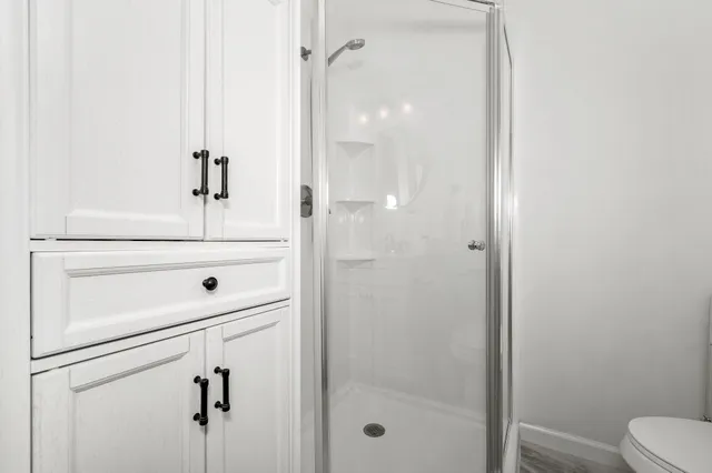 a bathroom with a shower a toilet and a sink