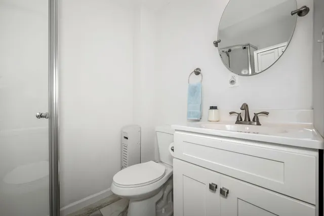 a bathroom with a toilet sink and mirror