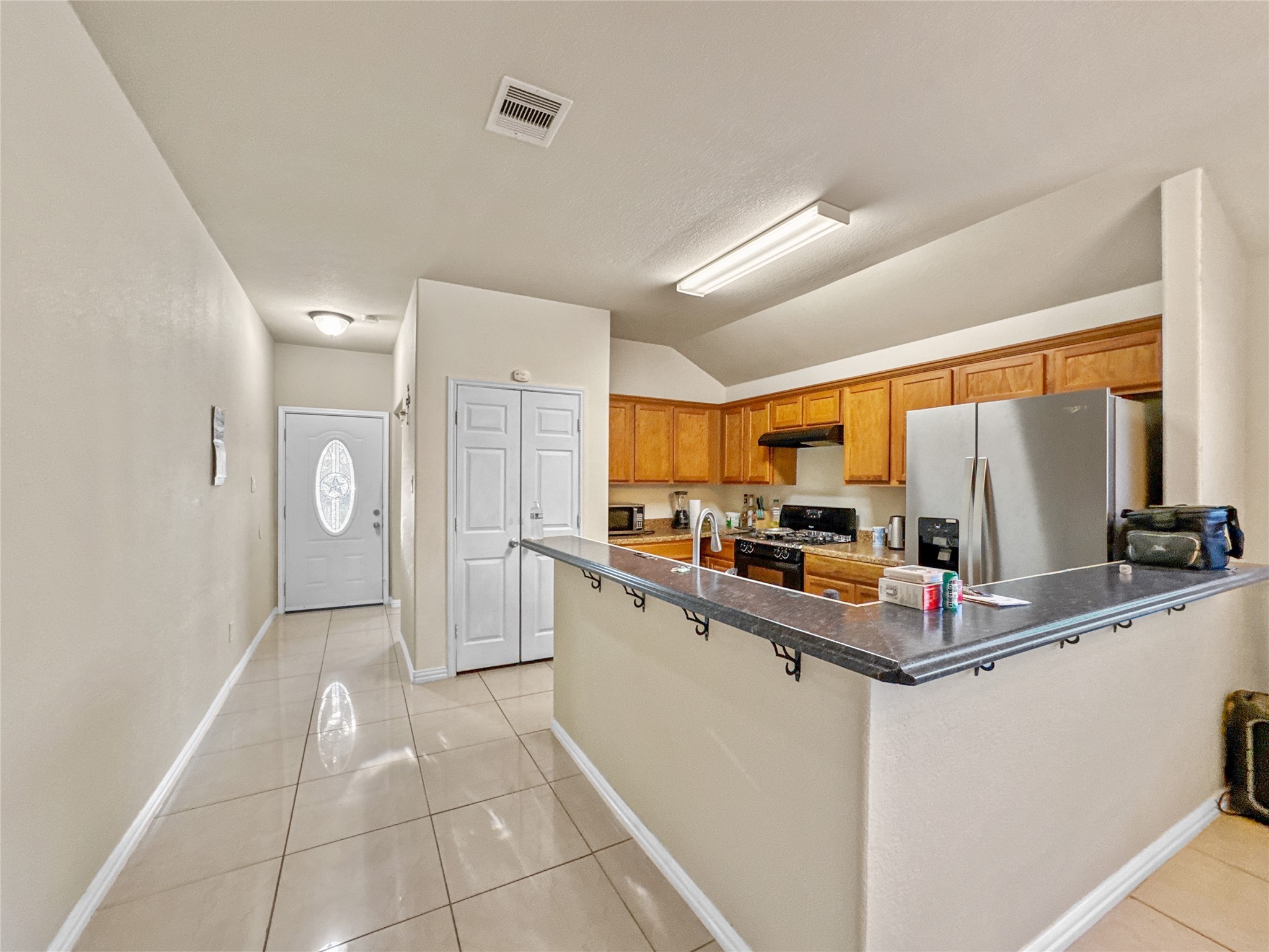 6614 Pine Tree Springs Houston, TX 77049 - Photo 2 of 14 a kitchen with kitchen island granite countertop a refrigerator and a sink