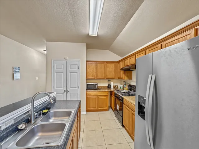 a kitchen with a sink stove and refrigerator