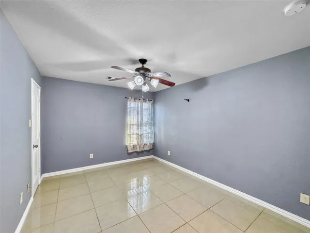 a view of a livingroom with a chandelier fan and windows