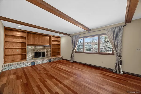 a view of a room with wooden floor and windows