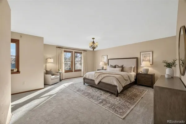 an empty room with windows and chandelier fan