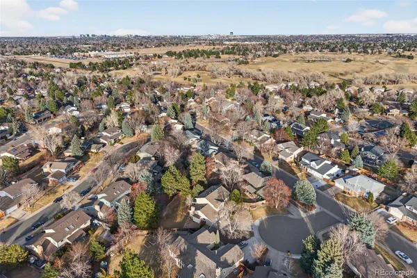 an aerial view of a house with a yard and trees all around