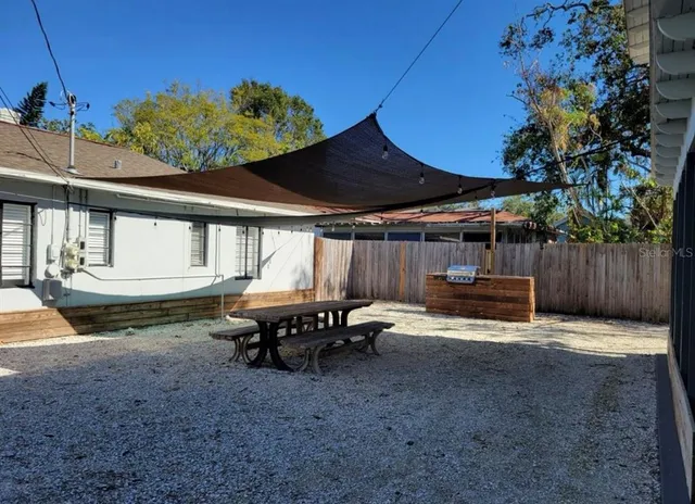 a view of a house with backyard and sitting area
