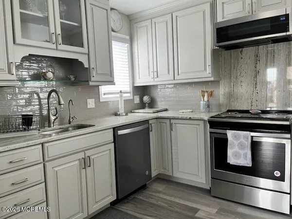 a kitchen with white cabinets and appliances