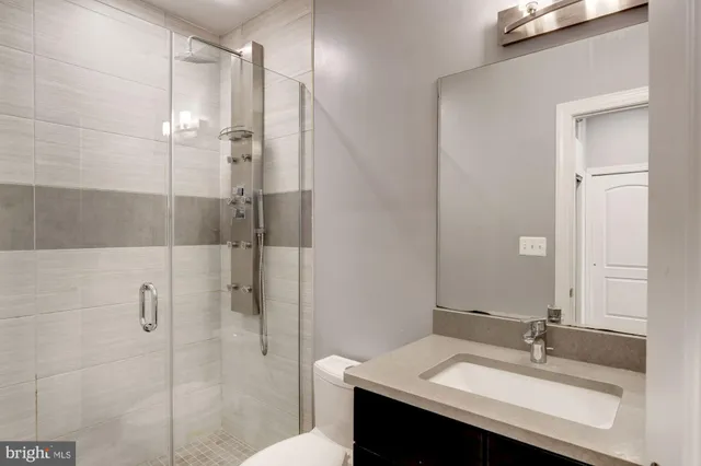 a bathroom with a sink shower and a mirror