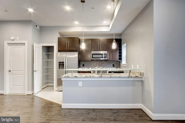 a view of kitchen with cabinets microwave and refrigerator