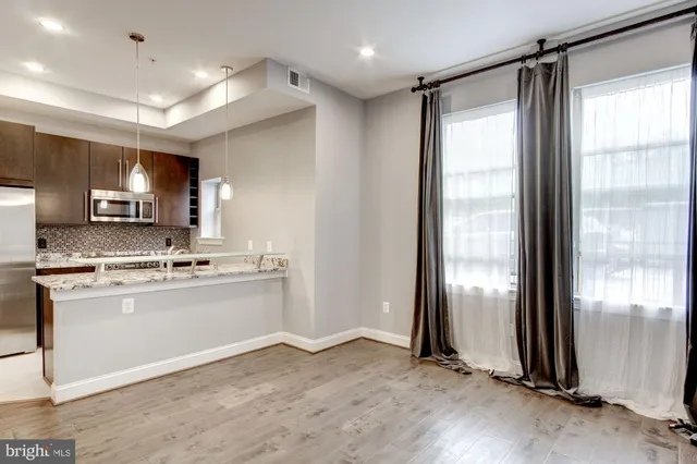 a kitchen with stainless steel appliances granite countertop a refrigerator a sink and a stove top oven