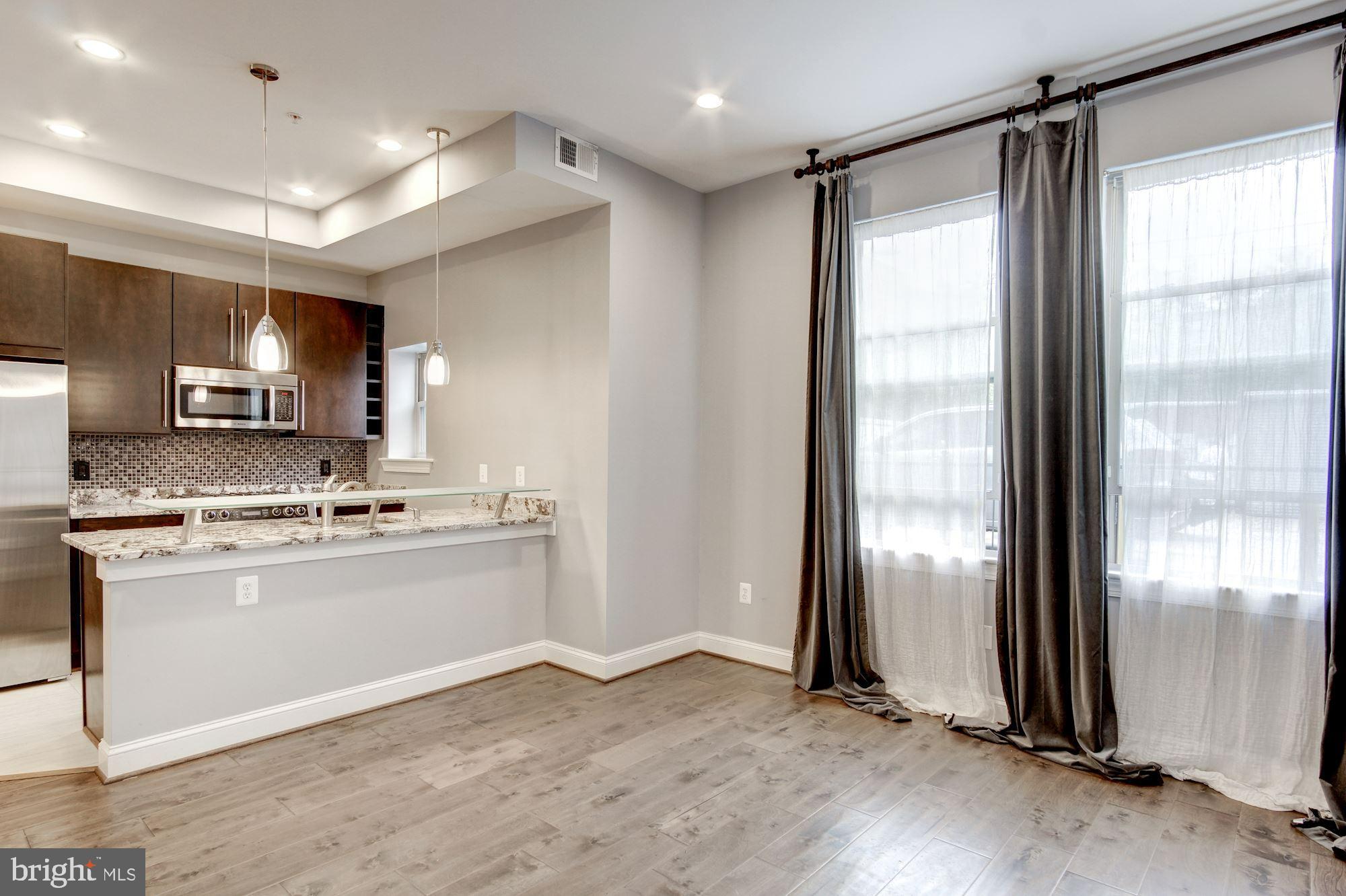 1333 Euclid Street Northwest, Unit 202 Washington, DC 20009 - Photo 5 of 14 a kitchen with stainless steel appliances granite countertop a refrigerator a sink and a stove top oven