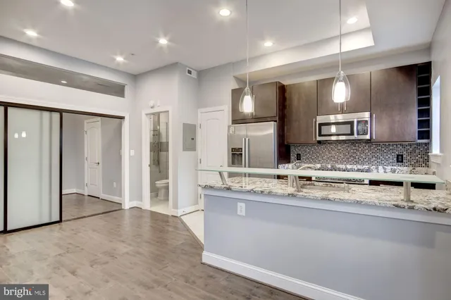 a view of a kitchen with a sink and a refrigerator