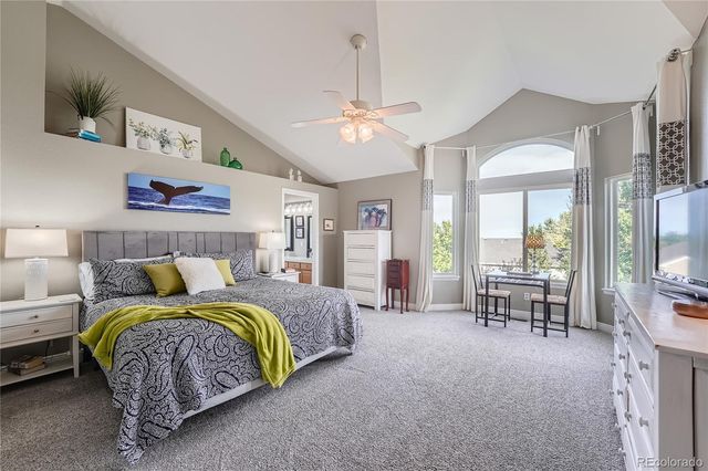 a bedroom with a bed couch and a large window
