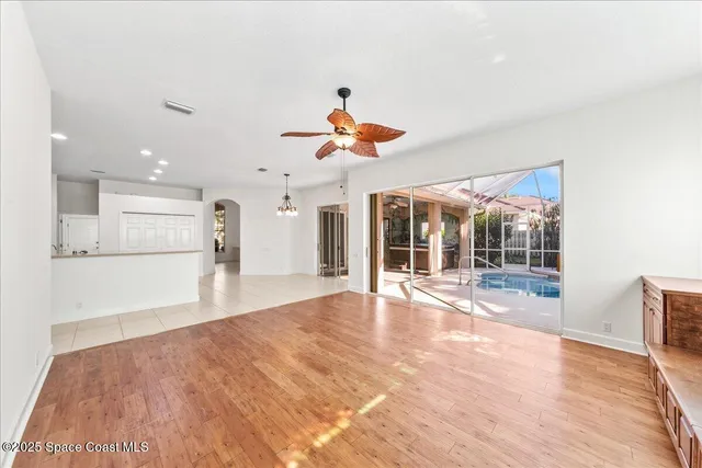 an empty room with a window and a ceiling fan