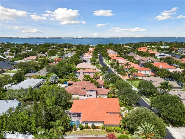 an aerial view of residential houses with outdoor space and trees