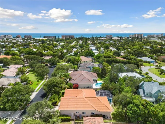 an aerial view of residential houses with outdoor space and trees
