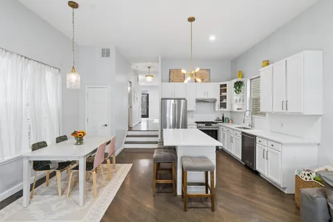 a large kitchen with a table and chairs