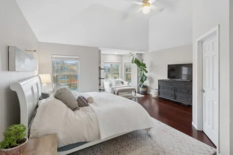 a spacious bedroom with a bed a couch and a chandelier