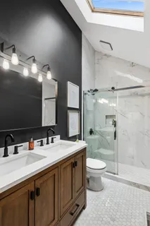 a bathroom with a double vanity sink toilet and a mirror