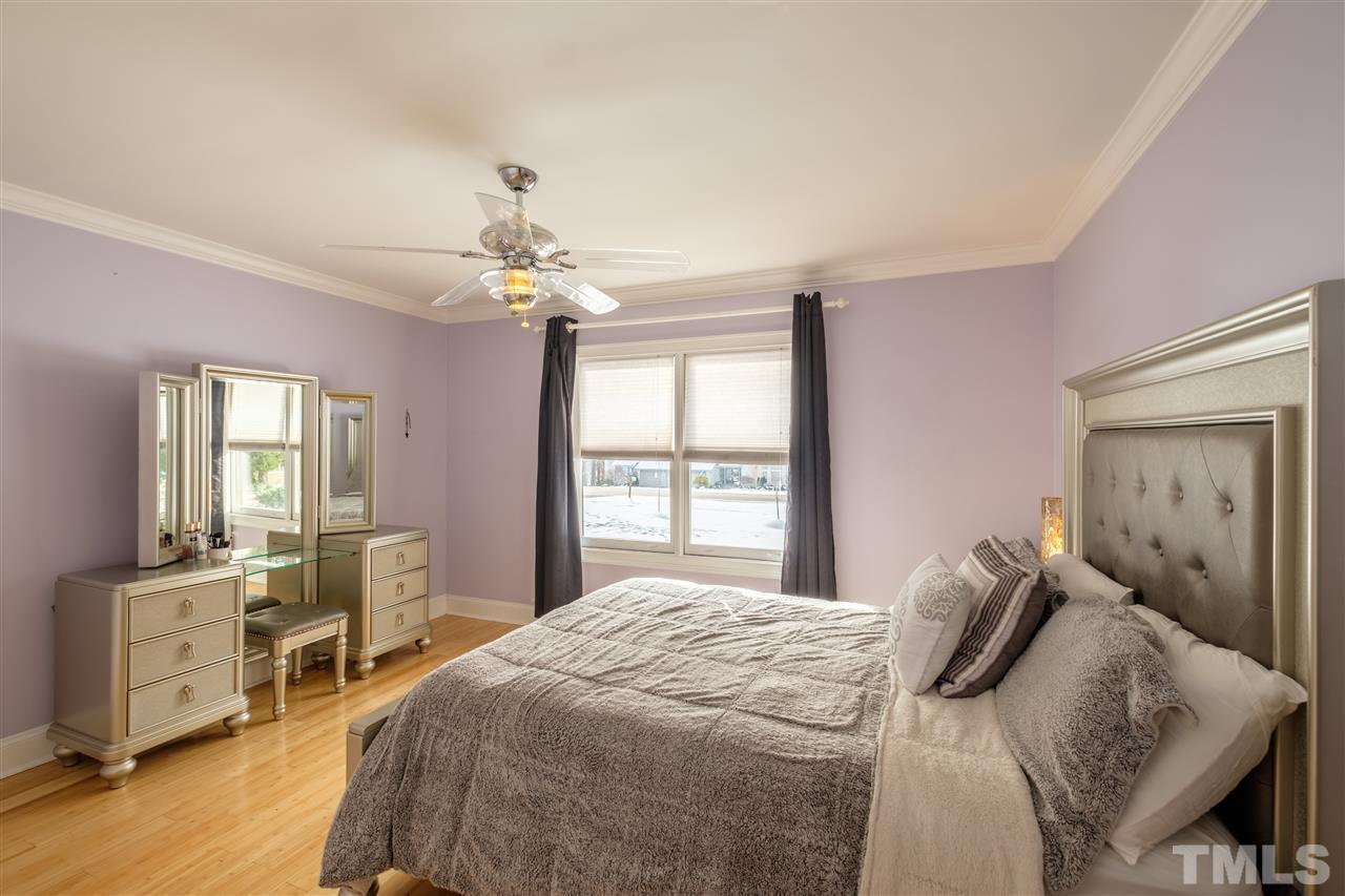 720 Malbay Lane Raleigh, NC 27615 - Photo 14 of 25 a bedroom with a bed and a chandelier