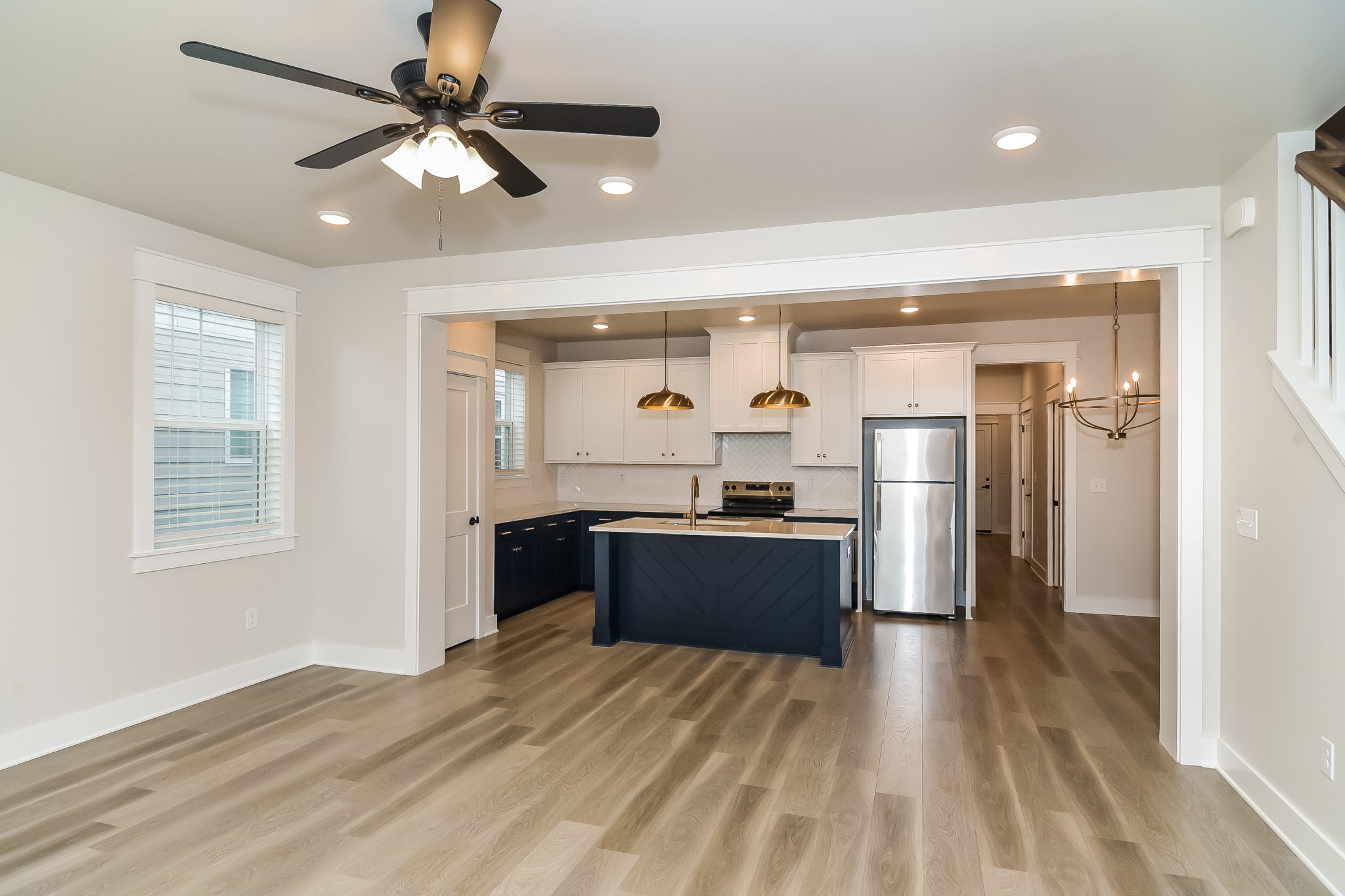228 Sounder Circle La Vergne, TN 37086 - Photo 5 of 17 a kitchen with stainless steel appliances kitchen island granite countertop a refrigerator a sink dishwasher a stove and a dining table with wooden floor