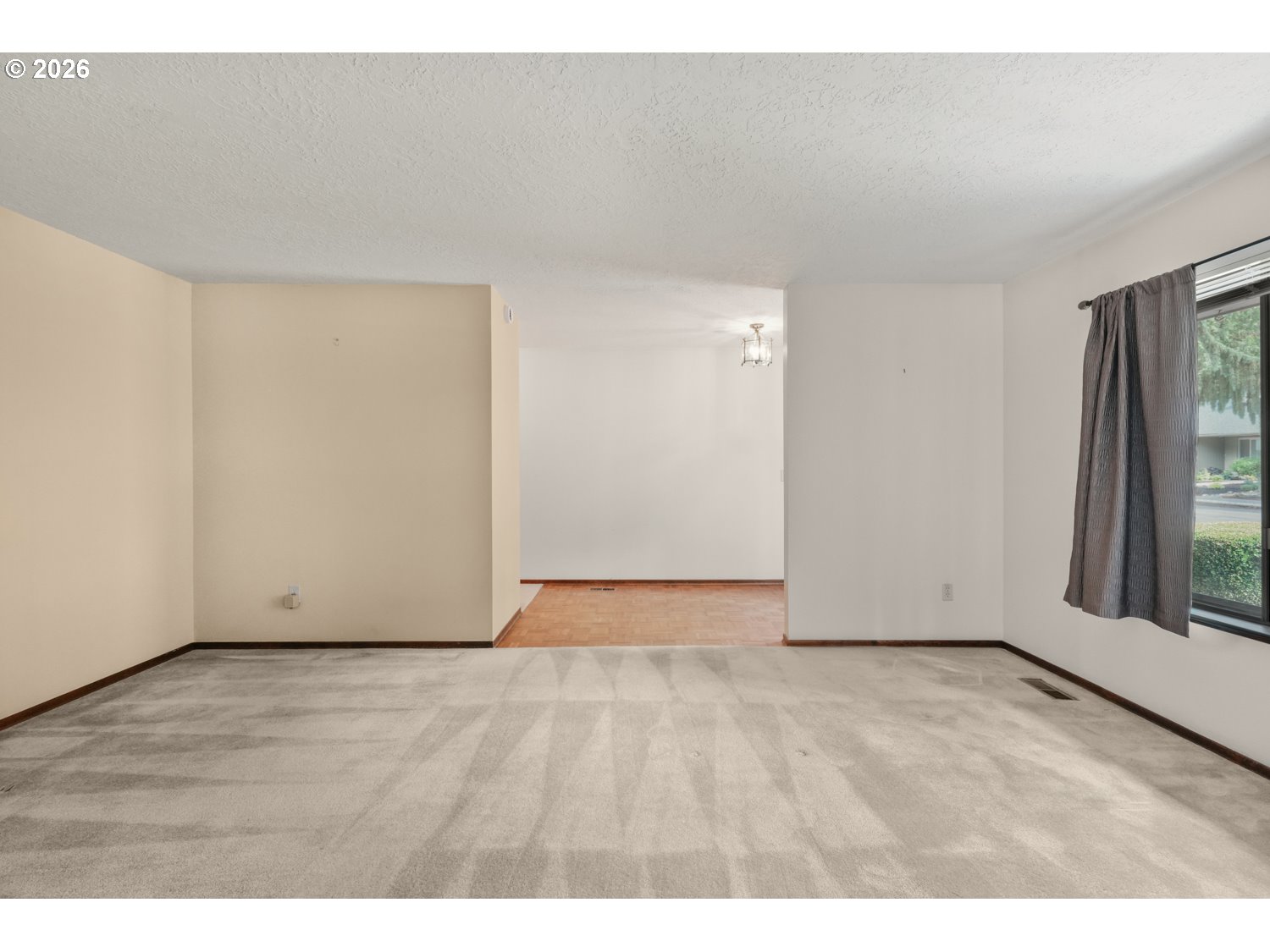 14155 Southwest 27th Street Beaverton, OR 97008 - Photo 5 of 27 a view of an empty room with wooden floor and a window