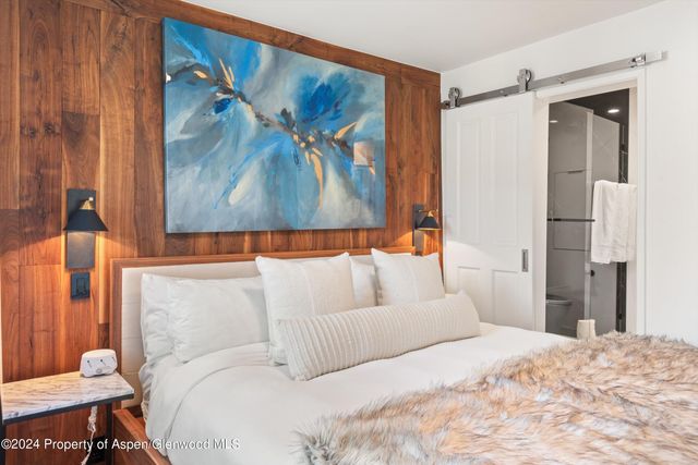 a bedroom with a bed and a painting on the wall