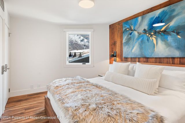 a bedroom with a bed and a painting on the wall