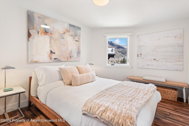 a bedroom with a bed and a painting on the wall